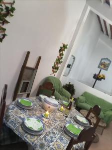 a dining room table with green dishes on it at O Mundo da Lua in Azeitao
