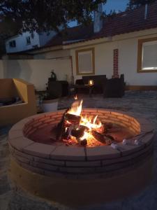 a fire pit in front of a house at night at O Mundo da Lua in Azeitao