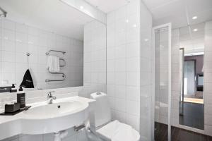 a white bathroom with a sink and a shower at Aiden by Best Western Stockholm Solna in Solna