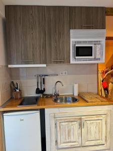 a kitchen with a sink and a microwave at SANT MORITZ CON GARAJE in Sierra Nevada