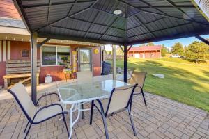 a patio with a table and chairs under an umbrella at Hills City Hideaway 12 Miles to Mt Rushmore! in Hill City