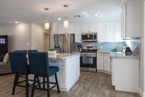 a kitchen with white cabinets and blue bar stools at Modern Arcadia Lite Oasis Pool Heater BBQ in Phoenix