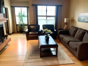 a living room with a couch and a coffee table at Luxurious Condo with Spa, Steam Room hosted by Fenwick Vacation Rentals in Canmore
