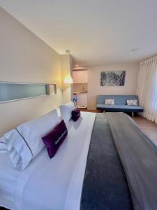 Hotel Living 55 في بوغوتا: سرير أبيض كبير في غرفة مع أريكة