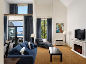 a living room with a blue couch and a fireplace at Huntingdon Hotel and Suites in Victoria
