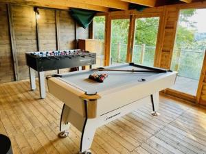 a ping pong table in a room with a pool table at The Crest Hillside Retreat With Hot Tub in Abertillery