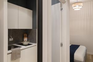 a kitchen with white cabinets and a sink at Central Trieste Marvel studio in Trieste