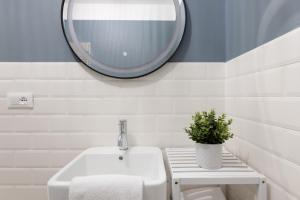 a bathroom with a white sink and a mirror at Central Trieste Marvel studio in Trieste +6 photos