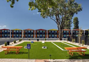 a courtyard with picnic tables in front of a building at Americana Motor Hotel in Flagstaff