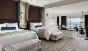 a hotel room with two beds and a desk at The Palazzo at The Venetian® in Las Vegas