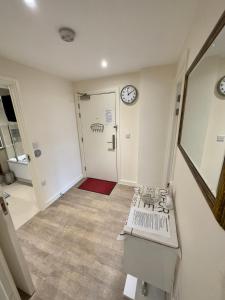 a room with a hallway with a clock on the wall at Luxury Penthouse in Greenwich sleeps 9 + parking in London