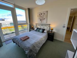 a bedroom with a bed and a large window at Luxury Penthouse in Greenwich sleeps 9 + parking in London