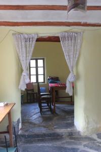 a room with curtains and a table and a window at Albergue Esmeralda - Camping in Sorata