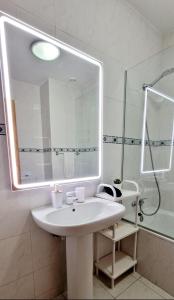 uma casa de banho com um lavatório branco e um espelho. em Ocean Pearl Apartment K no Funchal