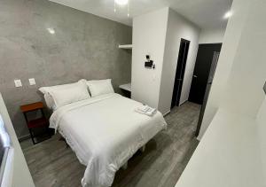 1 dormitorio con 1 cama blanca grande con almohadas blancas en LONGVIEW HOME-STUDIOS, en Tepic