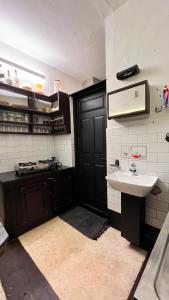 uma cozinha com um lavatório e uma porta preta em Apartment Near Indiranagar Metro Station. em Bangalore