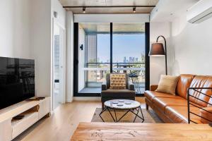 een woonkamer met een bank en een tv bij Modern Urban Retreat in Brunswick in Melbourne