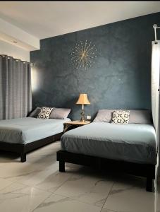 1 dormitorio con 2 camas y pared azul en DEPARTAMENTO CON TERRAZA Y VISTA para 6 personas en Chihuahua