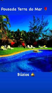 una piscina azul con sillas en un patio en Pousada Terra do Mar, en Búzios