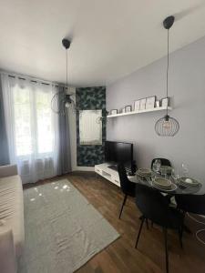 een woonkamer met een tafel en stoelen en een televisie bij Luxury modern Appartment Paris in Maisons-Alfort