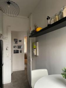 Cette chambre dispose d'une cuisine avec une table et une étagère. dans l'établissement Luxury modern Appartment Paris, à Maisons-Alfort