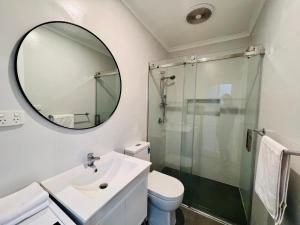 een badkamer met douche, wastafel en spiegel bij Cozy Self Contained Studio with Seperate Spacious Living room -Just a Stone's Throw from Newly Renovated Knox Westfield in East Melbourne in Wantirna South