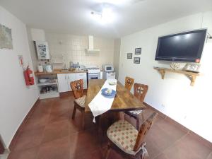 une cuisine et une salle à manger avec une table et des chaises en bois dans l'établissement Pirca Ushuaia, à Ushuaia 8 autres photos
