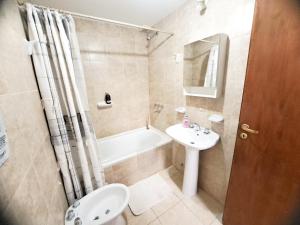 une salle de bains avec lavabo, baignoire et toilettes dans l'établissement Pirca Ushuaia, à Ushuaia