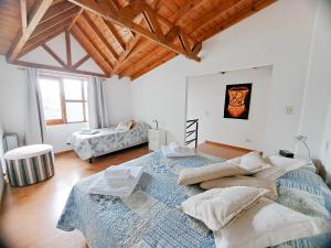 um quarto com 2 camas num quarto com tectos em madeira em Pirca Ushuaia em Ushuaia