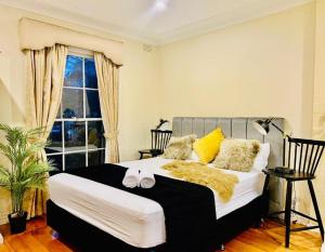 een slaapkamer met een bed met twee schoenen erop bij Cozy Self Contained Studio with Seperate Spacious Living room -Just a Stone's Throw from Newly Renovated Knox Westfield in East Melbourne in Wantirna South