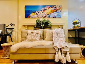 een bank in een woonkamer met een schilderij aan de muur bij Cozy Self Contained Studio with Seperate Spacious Living room -Just a Stone's Throw from Newly Renovated Knox Westfield in East Melbourne in Wantirna South