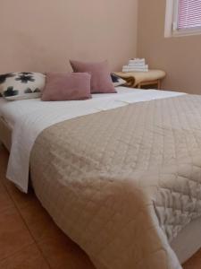 a large bed with a white comforter and pillows on it at Apartments Ant in Budva