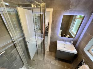 a bathroom with a shower and a sink and a mirror at Wembley Stadium Luxury 6 bed sleeps 14 in London