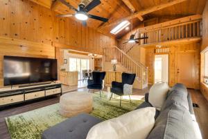a living room with a couch and a flat screen tv at Waterfront Mariposa Vacation Rental with Hot Tub in Mariposa