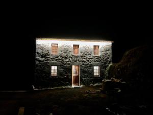 ein altes Steingebäude mit einer Tür im Dunkeln in der Unterkunft La petite Maison du Bonheur & Jacuzzi 