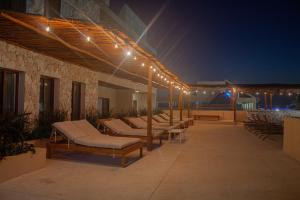 a patio with a bunch of beds and lights at Hotel Scappata in Progreso