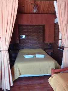 1 dormitorio con 1 cama con 2 almohadas en Los olivos en Capilla del Monte