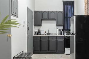 a kitchen with black cabinets and a black refrigerator at Apartment 253: Chelsea in New York