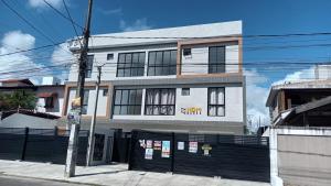 a white building with a black fence in front of it at Apartamento novo no Bessa in João Pessoa