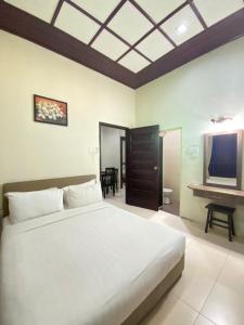 a bedroom with a large bed and a television at Jasmine Villa in Pantai Cenang