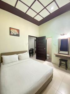 a bedroom with a large bed and a television at Jasmine Villa in Pantai Cenang +28 photos