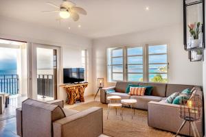 uma sala de estar com um sofá e uma televisão em Oceanfront Penthouse on the beach Bellevue 10 em Kralendijk