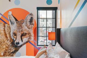 a bedroom with a painting of a fox on the wall at The Acoma House in Denver