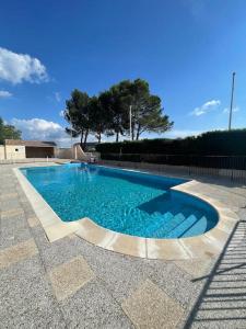 a swimming pool with blue water in a yard at Studio « Saint-Petersbourg » à Avignon in Avignon