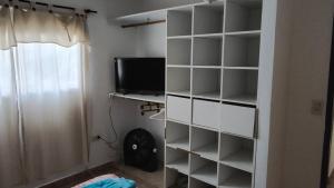 une étagère blanche avec une télévision dans la chambre dans l'établissement depto por dia, à General Roca