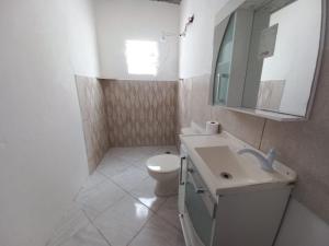 a bathroom with a toilet and a sink and a mirror at Residência in Caraguatatuba