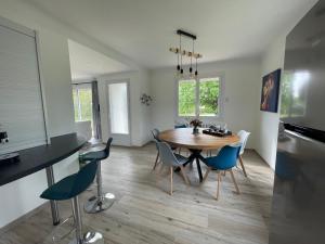 una cucina e una sala da pranzo con tavolo e sedie in legno di Maison contemporaine rénovée avec étang privé et terrasse, proche plage - 3 chambres, wifi inclus - FR-1-426-517 a Nieul-le-Dolent