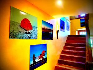 a wall with four pictures on a wall with stairs at Le Pavillon des Officiers in Mont-Dauphin