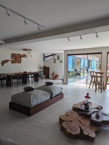 a bedroom with two beds and a table and chairs at Slater's House - Casa de praia em frente ao mar in Santa Luzia