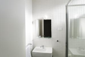 uma casa de banho branca com um lavatório e um chuveiro em Port Broughton Hotel and Sunnyside Motel em Port Broughton